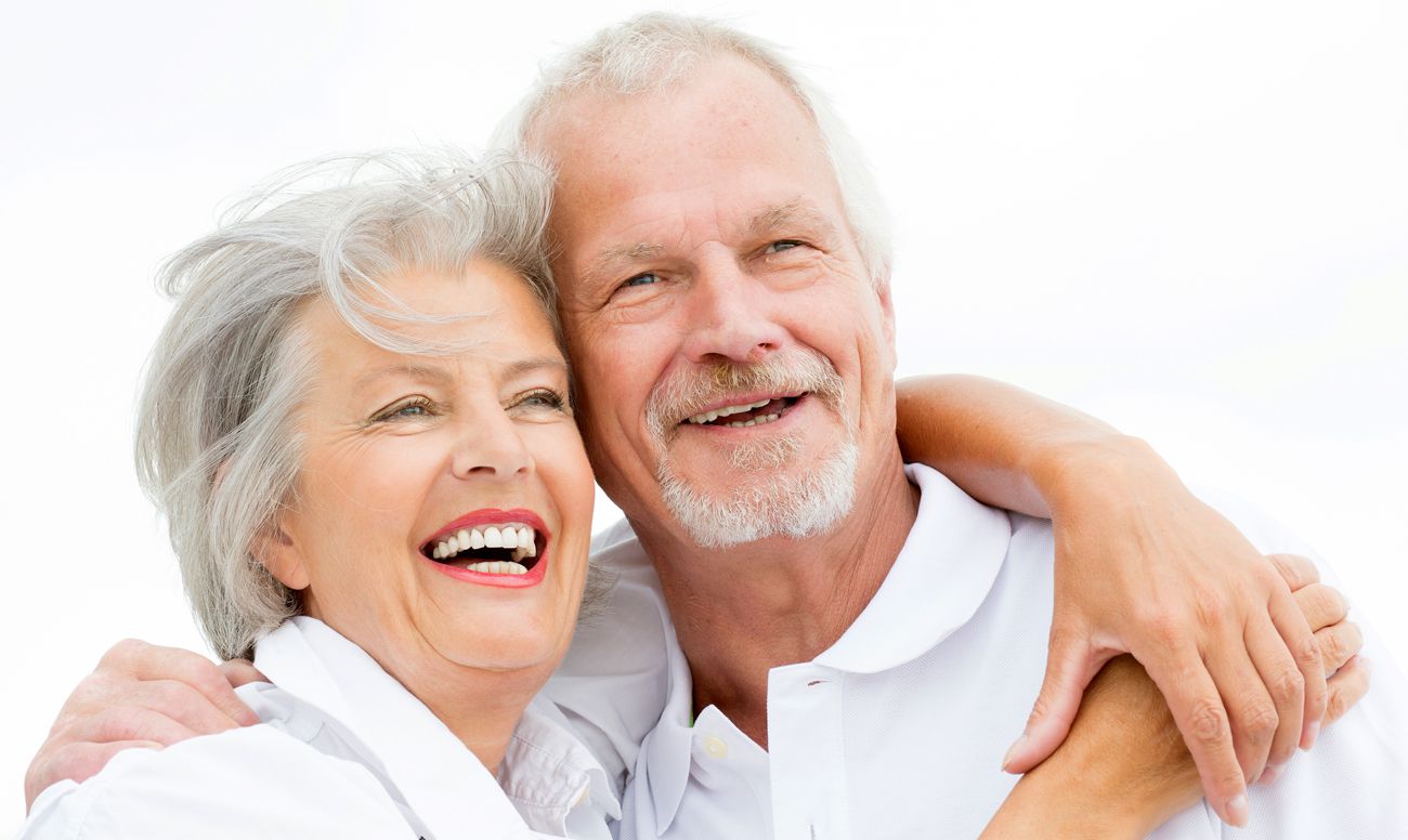 пожилые мужчина и женщина с хорошими зубами улыбаются